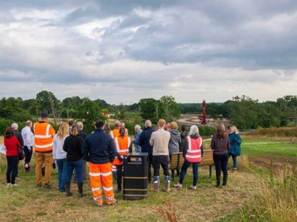Councillors stood, back to the camera in the building field