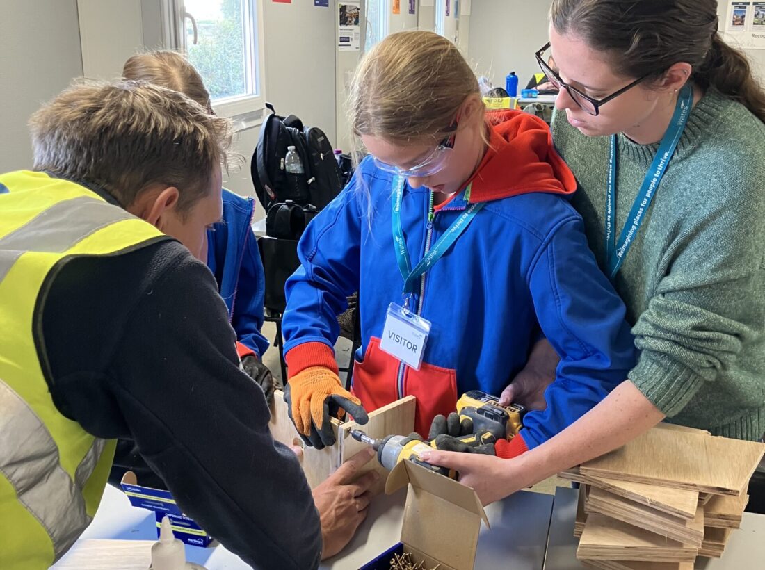 Girl Guide and staff helping to make a bird box
