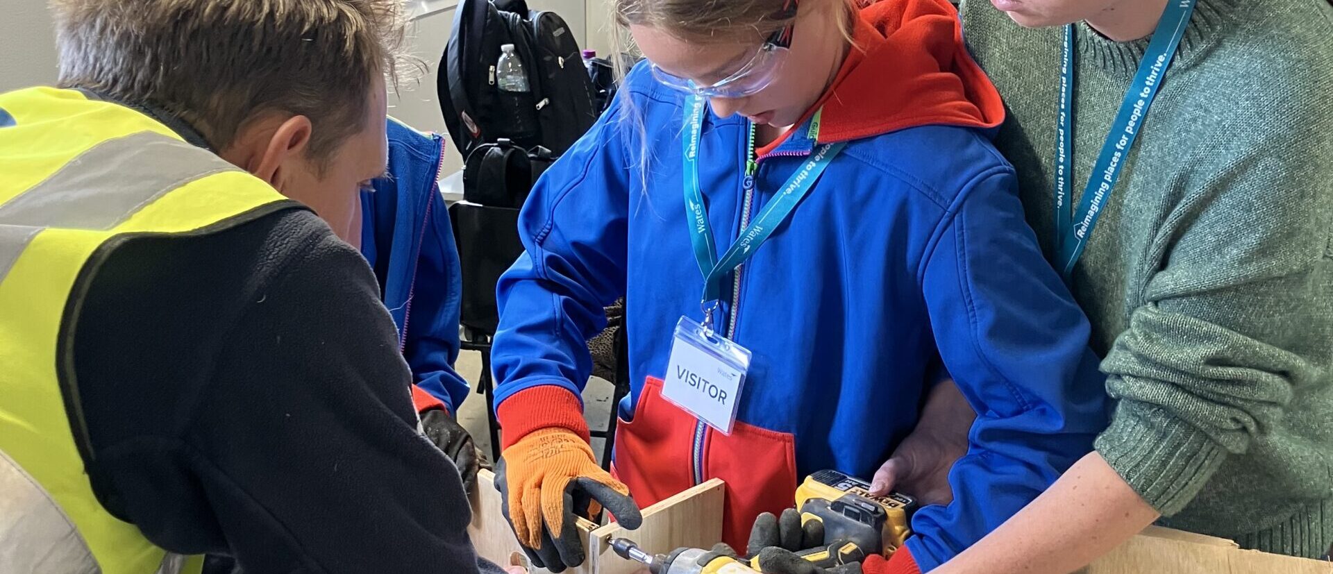 Girl Guide and staff helping to make a bird box