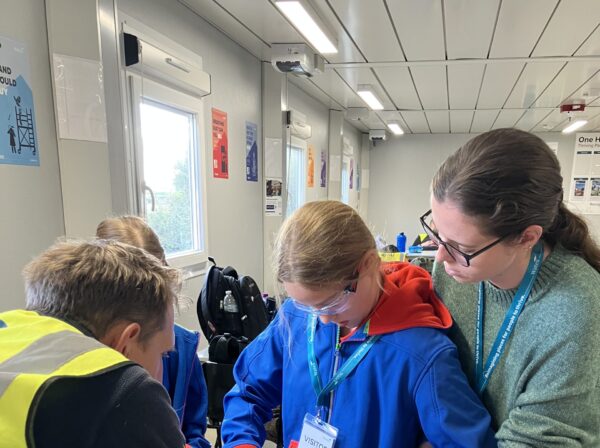 Girl Guide and staff helping to make a bird box
