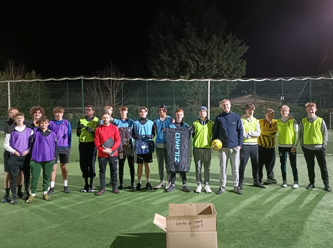Astro turf football pitch with players and donated kit