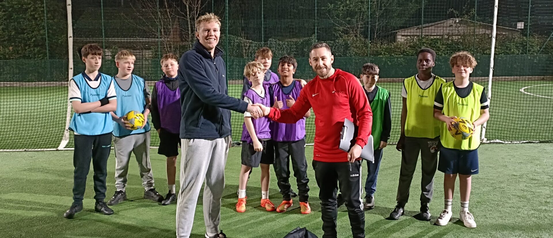 Astro turf football pitch with players and donated kit