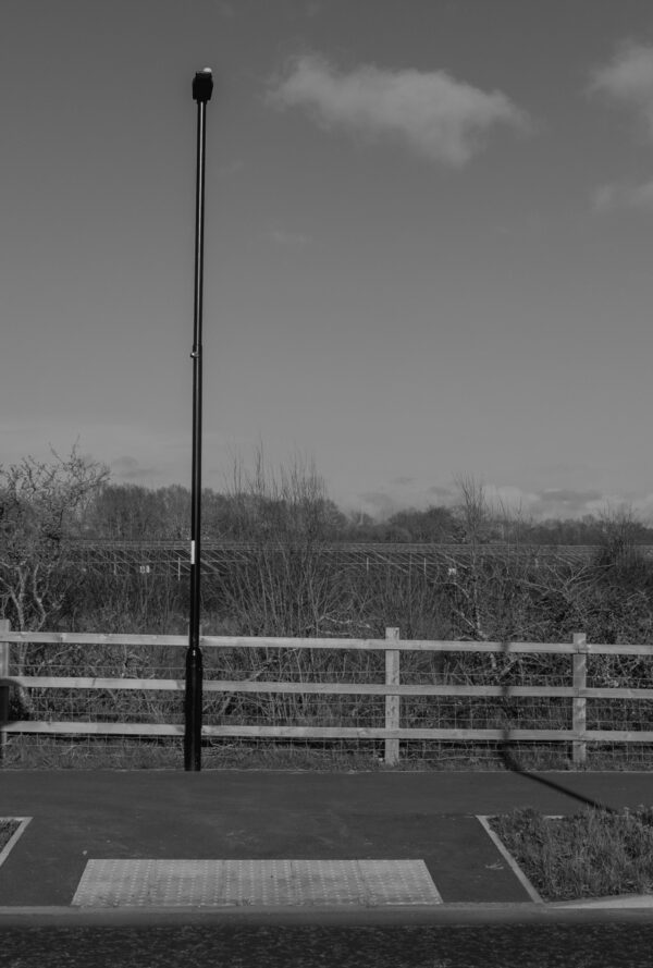 new pathway with pedestrian signage and wooden fencing, by the side of a road