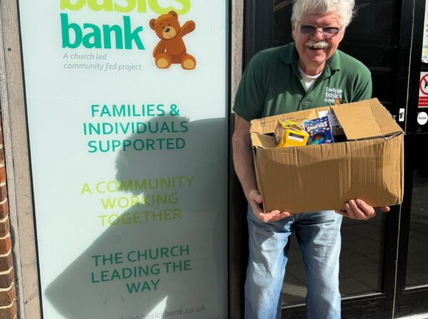Man holding a box of donated easter goods in front of Eastleigh Basics Bank Centre