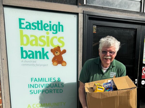 Man holding a box of donated easter goods in front of Eastleigh Basics Bank Centre