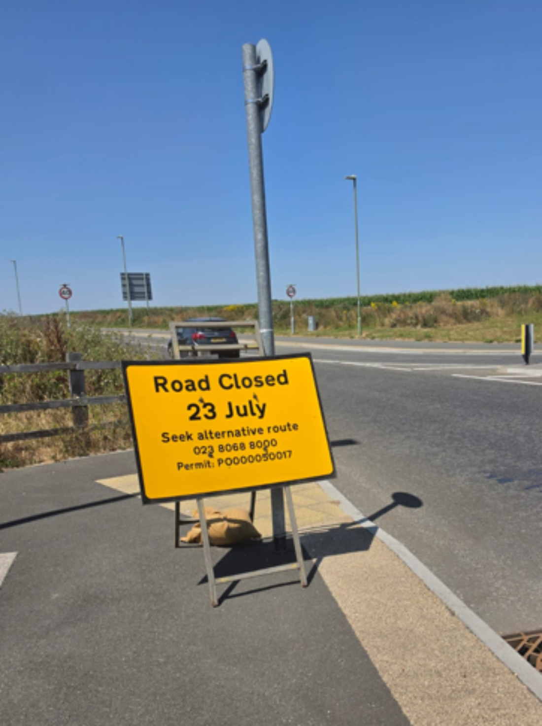 Yellow advanced warning road sign on the side of a road