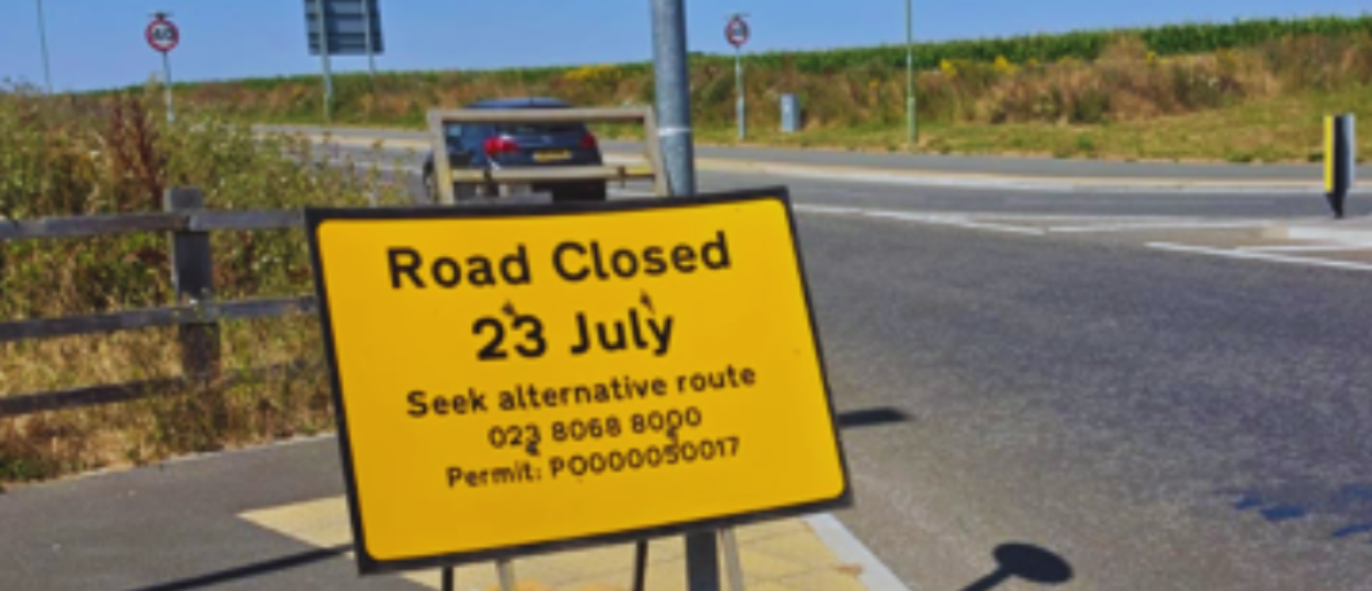 Yellow advanced warning road sign on the side of a road - Zoomed in