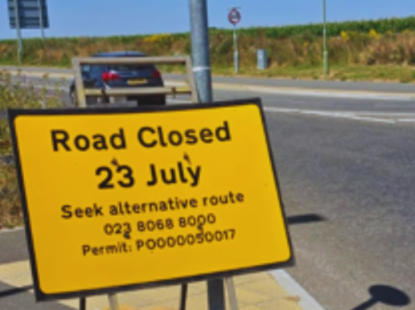 Yellow advanced warning road sign on the side of a road - Zoomed in