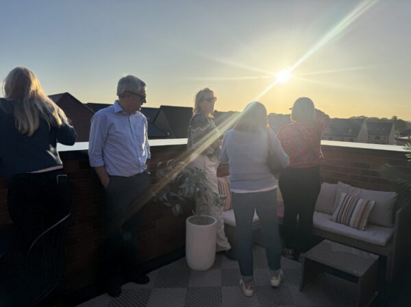 Parish council representatives looking around a OHH showhome - on a balcony in the sun