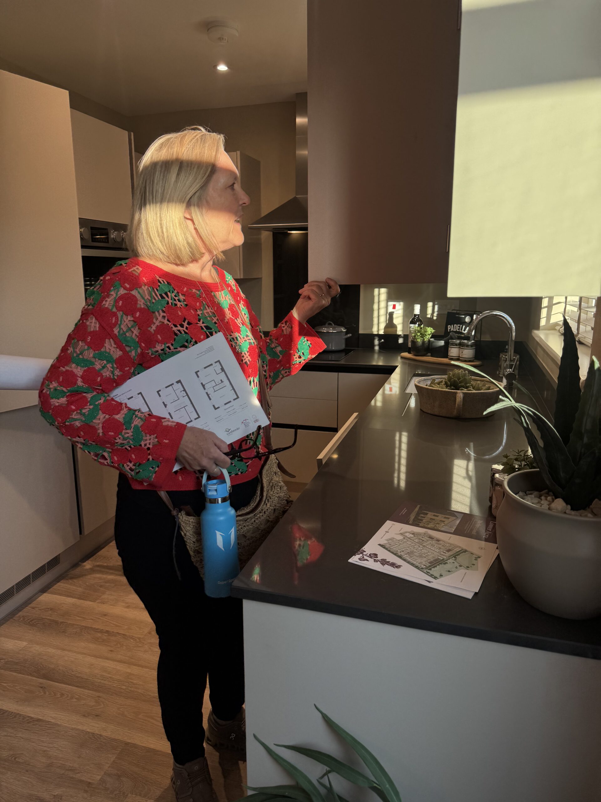 Councillor Trudie looking inside the show homes new kitchen cupboard